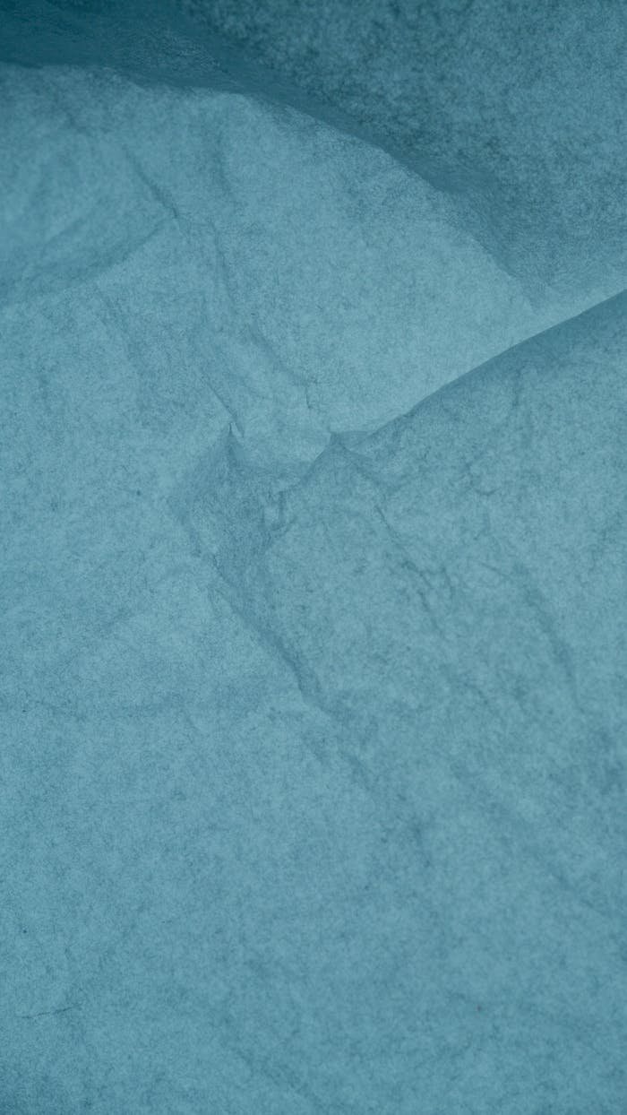 Crinkled blue paper texture suitable for backgrounds, design, and art projects.